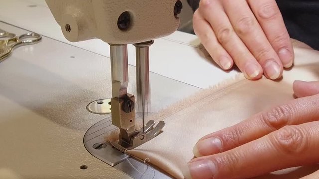 Close-up photo of sewing chocolate fabric.Woman sews fabric by a sewing machine