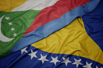 waving colorful flag of bosnia and herzegovina and national flag of comoros.