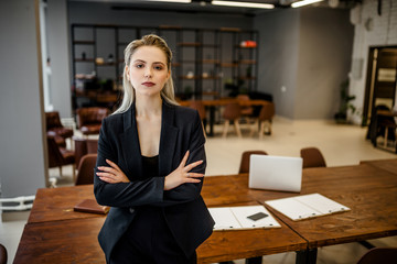 Portrait of a successful young business lady in a classic suit standing in the office