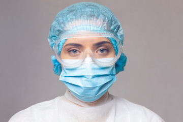 Portrait of a woman doctor virologist in protective uniform and goggles. close-up