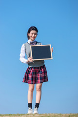 
Asian female students against blue sky background