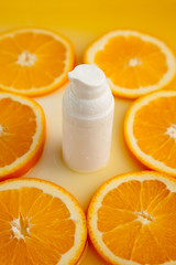 Cosmetic bottle with natural energy vitamin skin care. Cosmetic serum on an orange background.