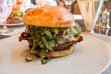 CHICAGO, ILLINOIS, UNITED STATES - DEC 12th, 2015: gourmet cheeseburger with french fries in background in a luxury hotel restaurant
