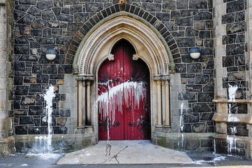 The door of a Roman Catholic Church suffers scorch damage from petrol bombs and paint during a...