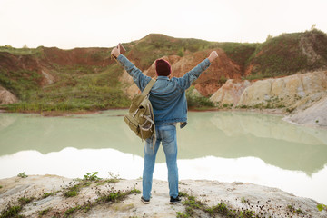 The man throws his hands up, indicating that his journey is at the end point