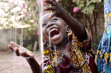 Fototapeta Incredibly Happy African Child Enjoying the Rain as a Water Scarcity Symbol obraz