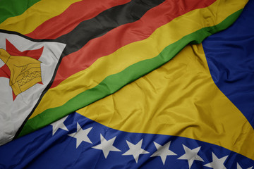 waving colorful flag of bosnia and herzegovina and national flag of zimbabwe.