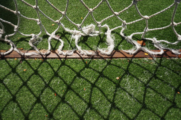 Ropes course climb at the playground. Green grass and net shadow.