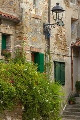 Fototapeta na wymiar Details of the windows and the brick walls of an ancient house, old town, Grado, Gorizia, Italy