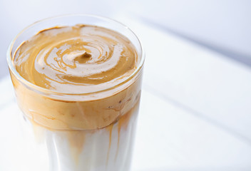 Iced frothy Dalgona Coffee, a trendy fluffy creamy whipped coffee. Korean drink latte espresso with coffee foam. made of instant coffee, sugar, hot water and cold milk. 