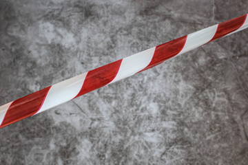 Red and white barrier tapes isolated on dark background.