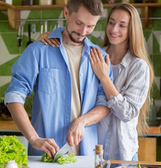 Young vegan couple making healthy dinner of fresh vegetables