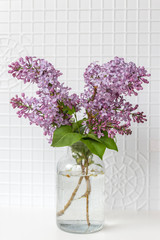 Bright blooms of spring lilacs on a table in house. Spring purple flowers close-up. Selected focus.