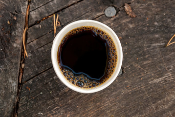cup of coffee on wooden outdoor table. Nice camping picture