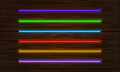 A set of neon brushes. Set of colorful light objects on a dark tree background.