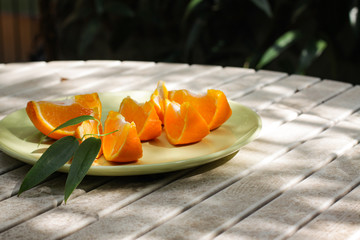 Fresh orange served outside in garden on white table  in sun lights close up