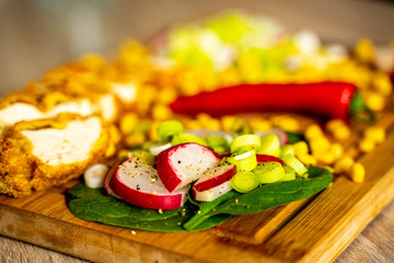 Macro photo of chopped radishes on spinach leaves