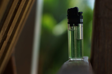 lighter on wooden chair with bokeh background, Portable device used to ignite a flame    