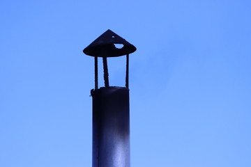Chimney pipe. Old chimney hood with burnt hole.Smoke and soot comes out of the chimney