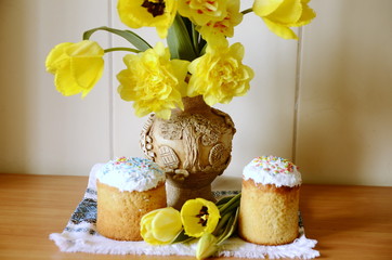 Religion and culture. Easter day. On the table are holiday cakes, a vase with beautiful yellow daffodils.