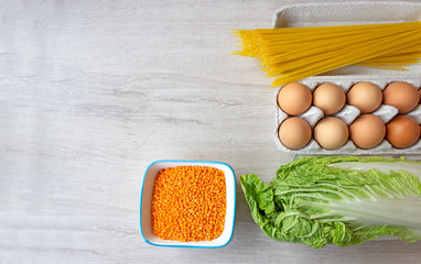 Vegetable set of spaghetti products, cabbage, a tray of chicken eggs and lentils. Copy space. Food donation
