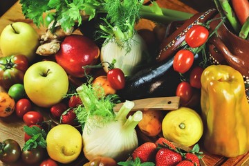 rustic composition of fruit and vegetables on wooden table illuminated by a warm light
