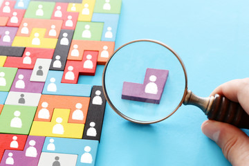 image of tangram puzzle blocks with people icons over wooden table ,human resources and management...