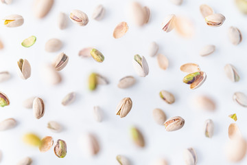 In shell pistachio nuts flying above white background, levitation effect