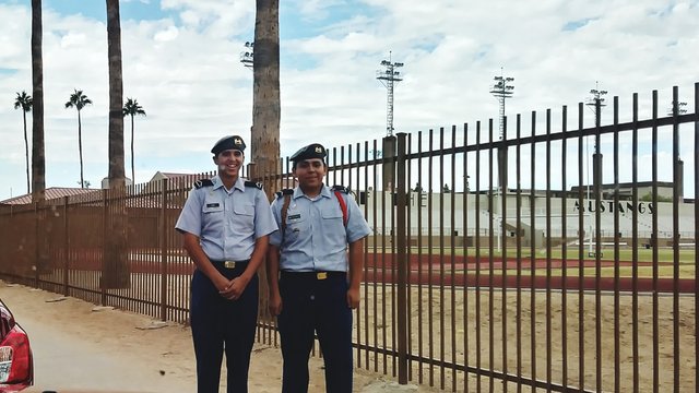 Portrait Of Security Guards Standing By Fence