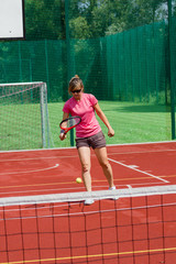 Obraz premium Female tennis player bouncing tennis ball on a court