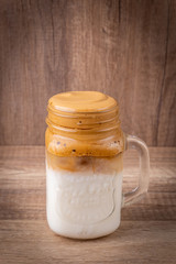 Iced Dalgona Coffee, a trendy fluffy creamy whipped coffee on a wooden table