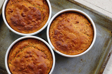 Three just baked vegan carrot cakes in a cake mold
