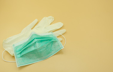 used green paper mask surgical on latex glove protect and filter dust pollution and disease corona virus. safety medical equipment. Isolated on yellow background.