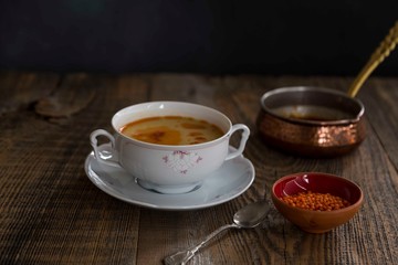Red Lentil Soup with ingredients on wooden background, top view, copy space. Traditional turkish or arabic lentil and vegetable spicy soup, healthy vegan food.