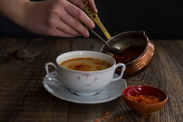 Red Lentil Soup with ingredients on wooden background, top view, copy space. Traditional turkish or arabic lentil and vegetable spicy soup, healthy vegan food.