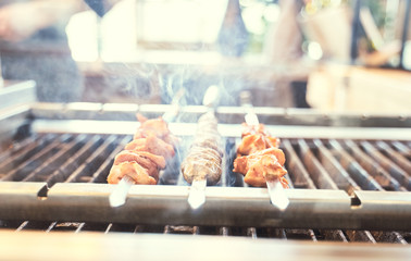Preparation of shish kebab bbq.  Grilled pork on a white plate on a wooden table. Grilled pork skewers - 341415678