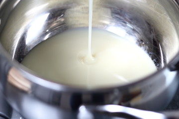 Pouring sweetened condensed milk into pan. Making Boston Banoffee Pie.