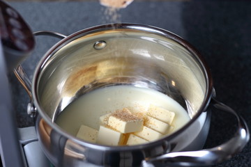 Pouring brown sugar into condensed milk with diced butter. Making Boston Banoffee Pie.