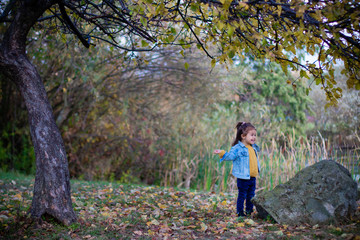 a child playing in the park alone near a pond or lake