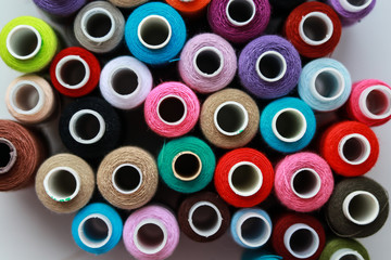 balls of sewing thread of different colors on a white background