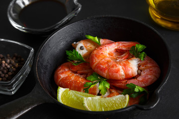 Grilled prawns with pepper parsley and lime on a dark background