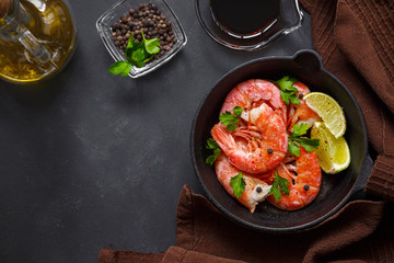 Grilled prawns with pepper parsley and lime on a dark background