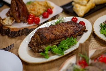 
meat with greens and tomatoes on a plate