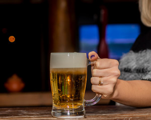 Hand holding mug of beer chopp