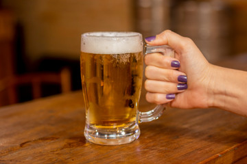 Hand holding mug of beer chopp