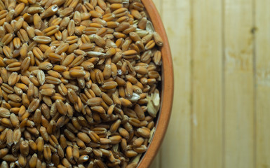 bowl with wheat on a wooden background