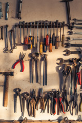 Workshop garage scene. Old tools hanging on wall in workshop, Tool shelf against a table and wall, vintage garage style