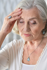 Portrait of sad ill senior woman with headache