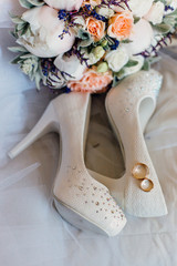 
bridal bouquet and wedding rings and shoes of the bride