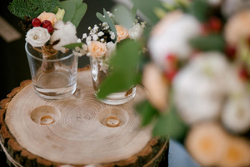 
wedding rings on a wooden stand with a bouquet
